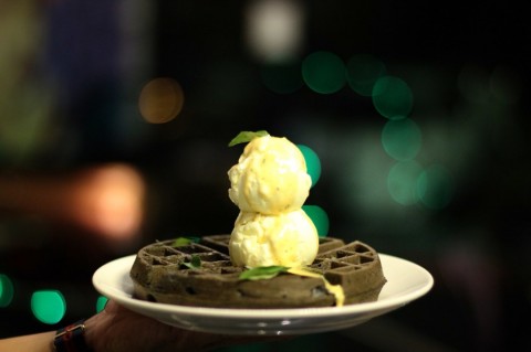 Charcoal waffle with vanilla ice cream and salted egg yolk sauce 